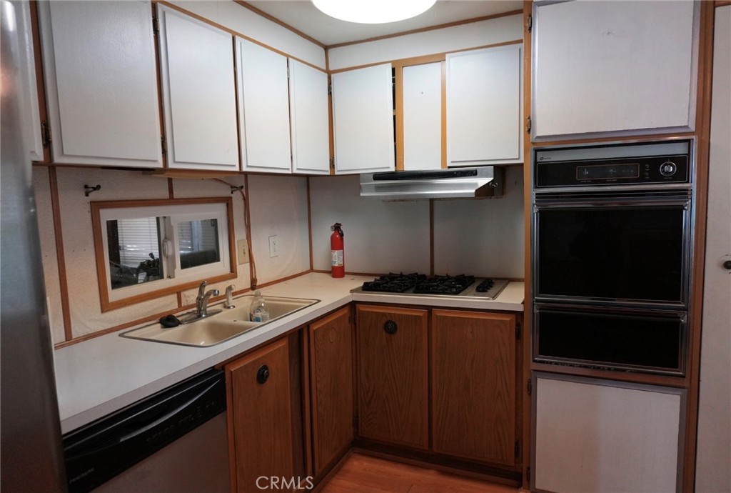 15940 Stoddard Wells Road, Unit 50HWY Victorville, CA 92395 - Photo 7 of 15 a kitchen with stainless steel appliances a stove and a refrigerator