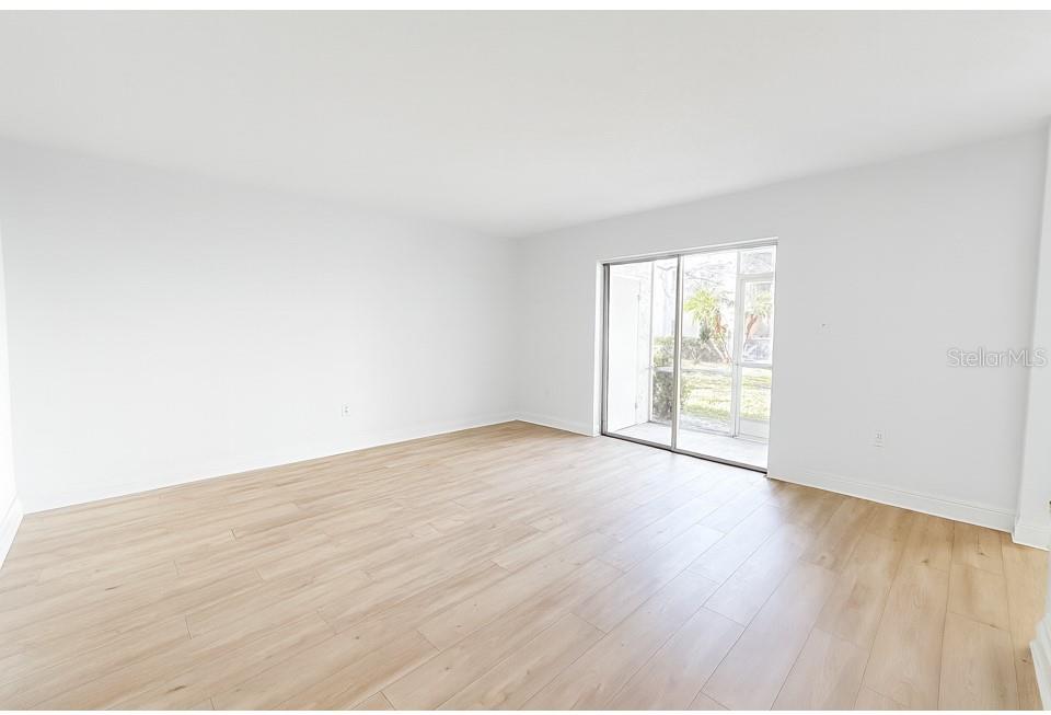 247 South McMullen Booth Road, Unit 23 Clearwater, FL 33759 - Photo 4 of 47 an empty room with wooden floor and windows