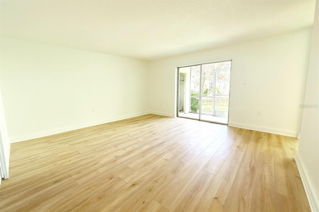 247 South McMullen Booth Road, Unit 23 Clearwater, FL 33759 - Photo 5 of 47 an empty room with wooden floor and windows