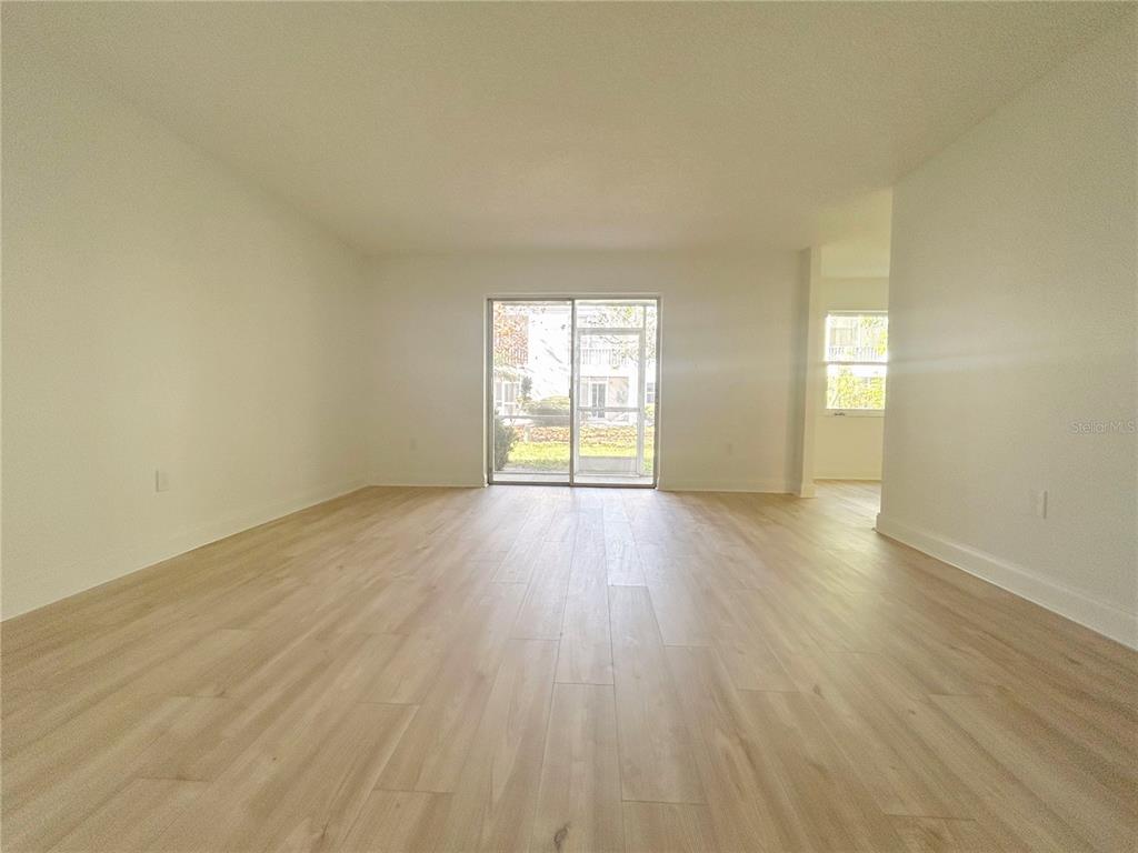 247 South McMullen Booth Road, Unit 23 Clearwater, FL 33759 - Photo 6 of 47 an empty room with wooden floor and windows
