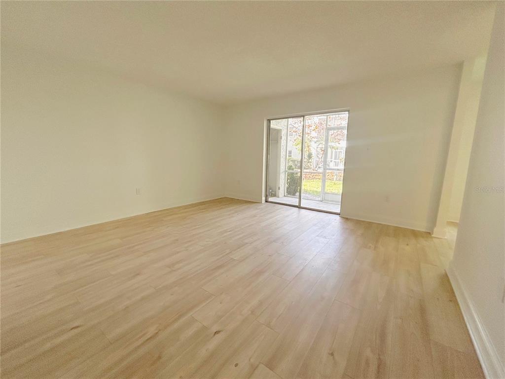 247 South McMullen Booth Road, Unit 23 Clearwater, FL 33759 - Photo 7 of 47 a view of an empty room with wooden floor and a window