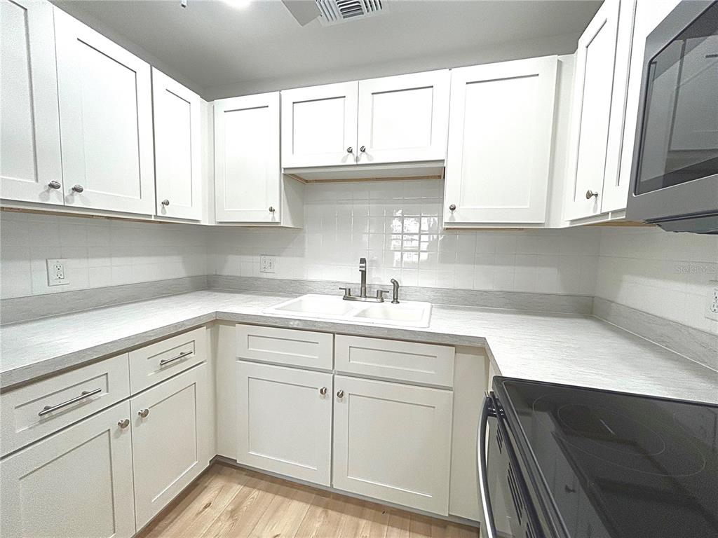 247 South McMullen Booth Road, Unit 23 Clearwater, FL 33759 - Photo 10 of 47 a kitchen with white cabinets and a sink