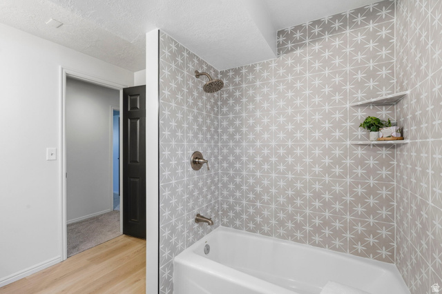 2460 Allison Way Syracuse, UT 84075 - Photo 18 of 24 Bathtub shower featuring patterned tile surround, brushed nickel fixtures, and an integrated corner shelf
