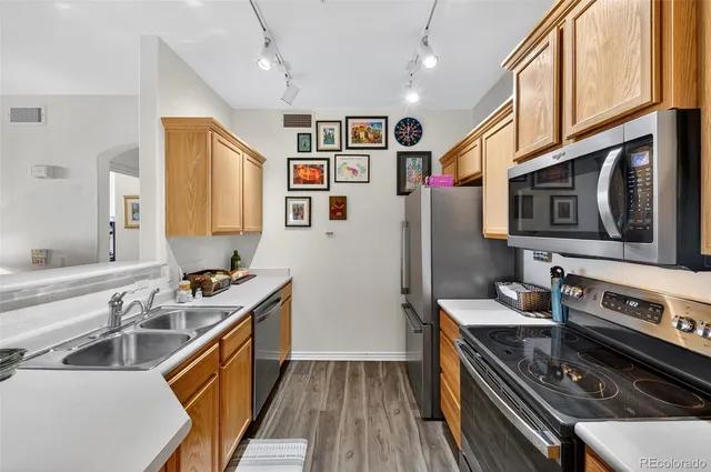 a kitchen with stainless steel appliances a stove a sink dishwasher a refrigerator and a stove