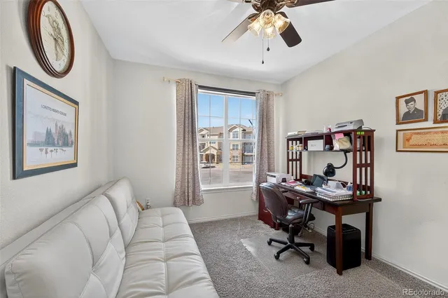 a view of a workspace with furniture and a window