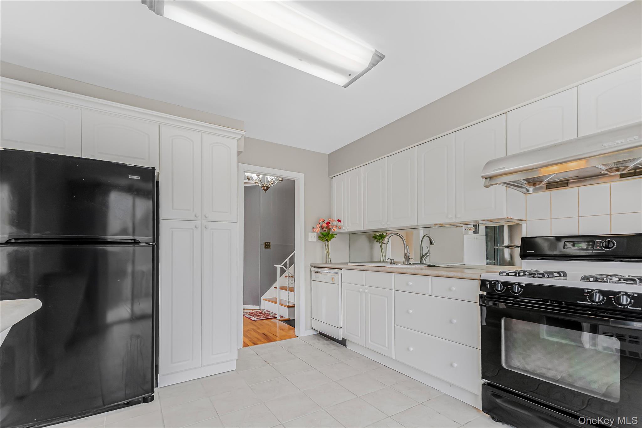 2 Deer Path Lane Syosset, NY 11791 - Photo 16 of 41 a kitchen with stainless steel appliances a refrigerator a sink a stove and cabinets