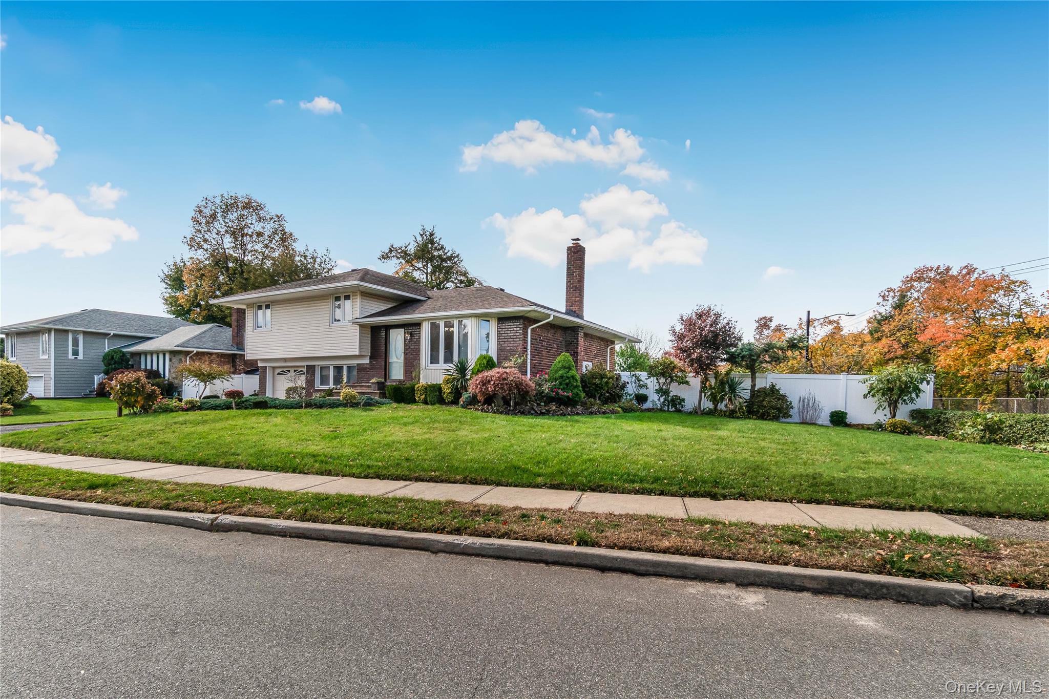 2 Deer Path Lane Syosset, NY 11791 - Photo 40 of 41 a view of a white house next to a yard and road