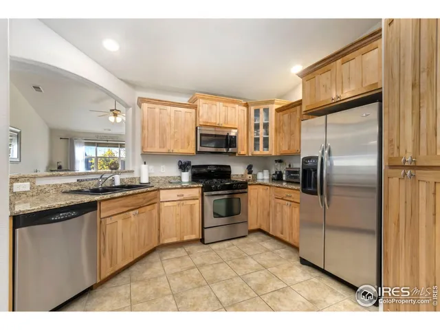 a kitchen with granite countertop a refrigerator and a sink