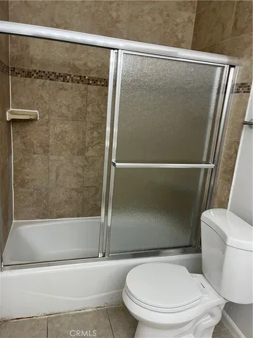 a white toilet sitting next to a bath tub and a shower