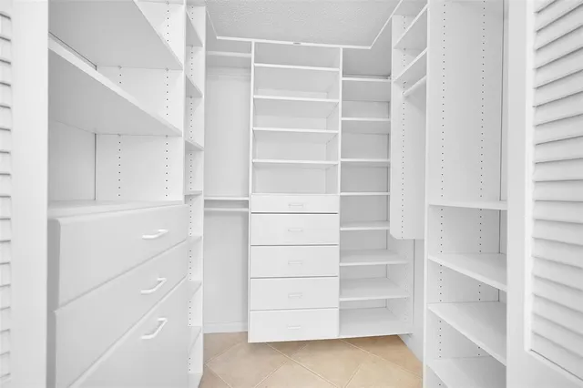 a view of walk in closet with empty racks