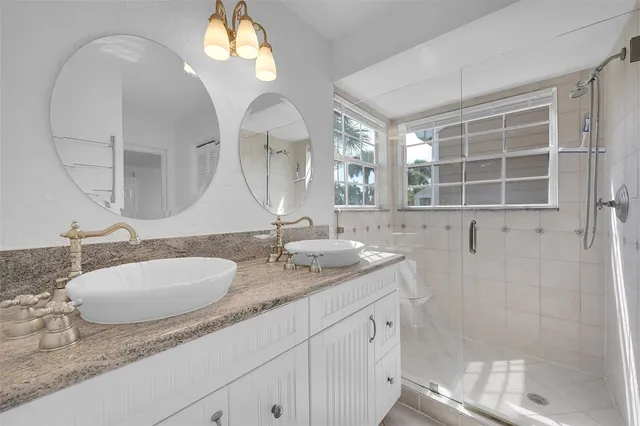 a bathroom with double vanity sinks and a mirror