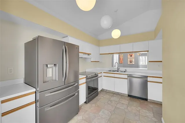 a kitchen with a refrigerator sink and stove top oven