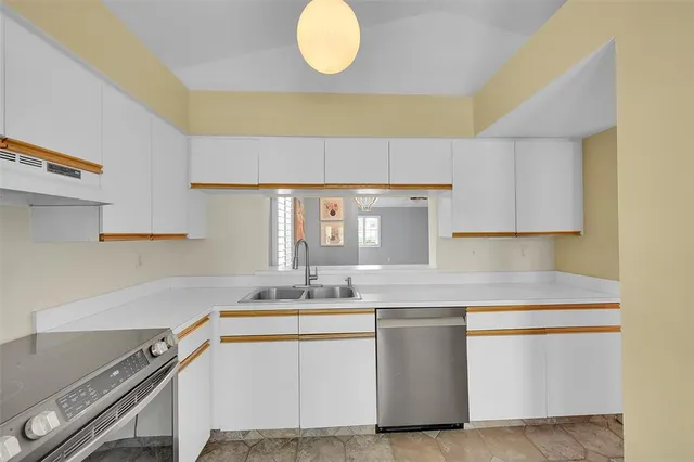a kitchen with a sink cabinets and wooden floor
