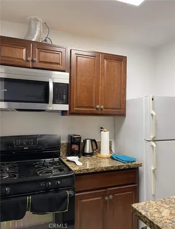 a kitchen with stainless steel appliances granite countertop a stove and a microwave