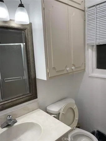 a bathroom with a toilet sink and mirror