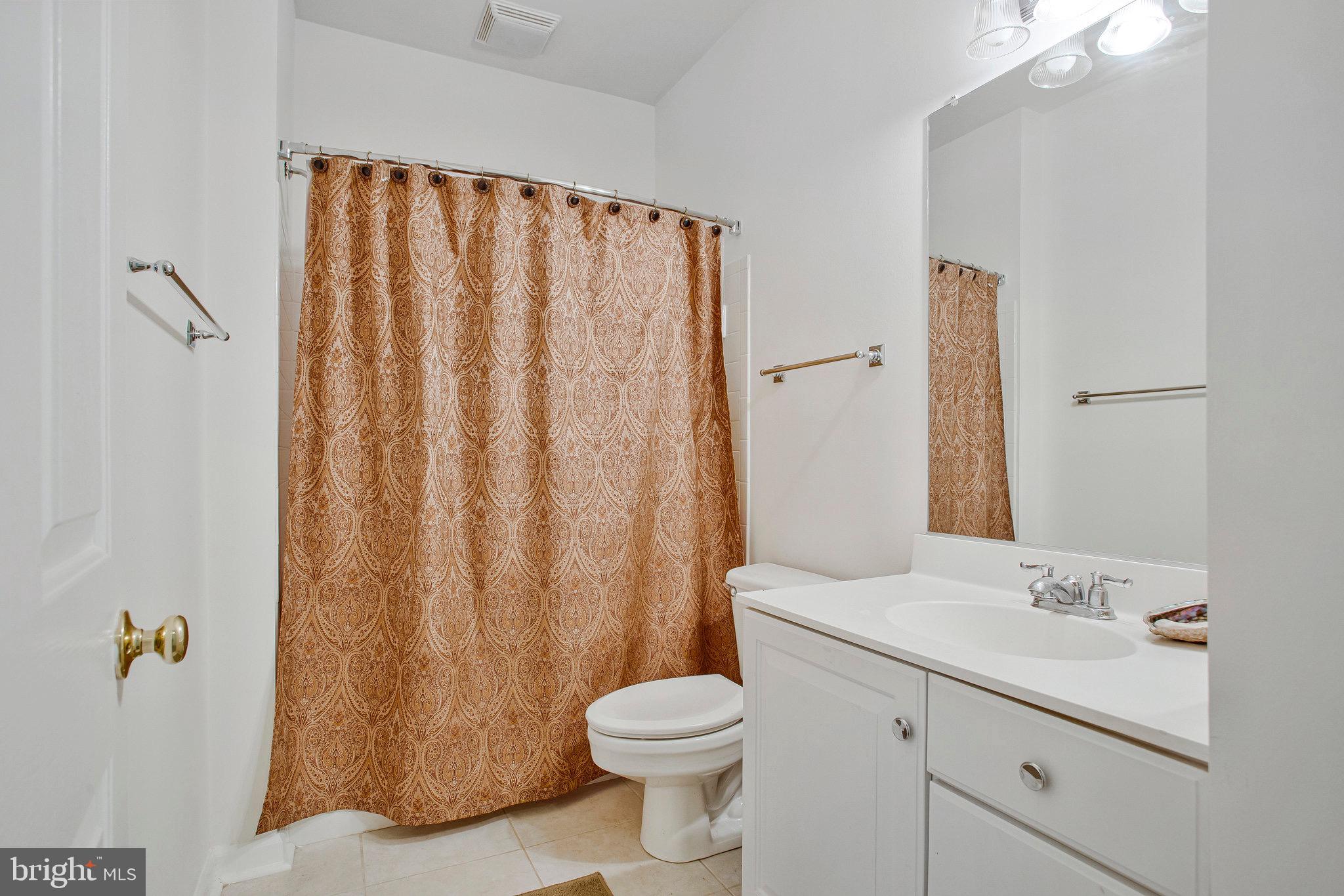 322 Hamlet Circle Edgewater, MD 21037 - Photo 14 of 21 a bathroom with a sink a toilet and shower curtain