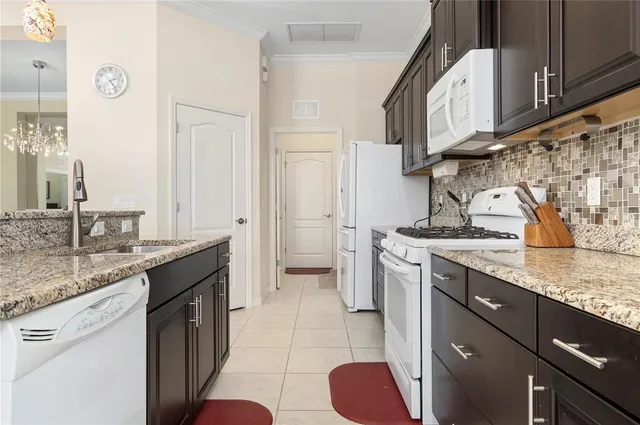 a kitchen with stainless steel appliances granite countertop a sink stove and cabinets