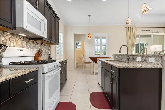 a kitchen with granite countertop a sink stove and cabinets