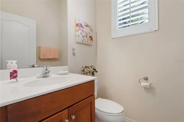 a bathroom with a sink mirror vanity and toilet