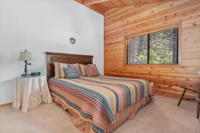 a bedroom with 2 bed and a lamp on dresser