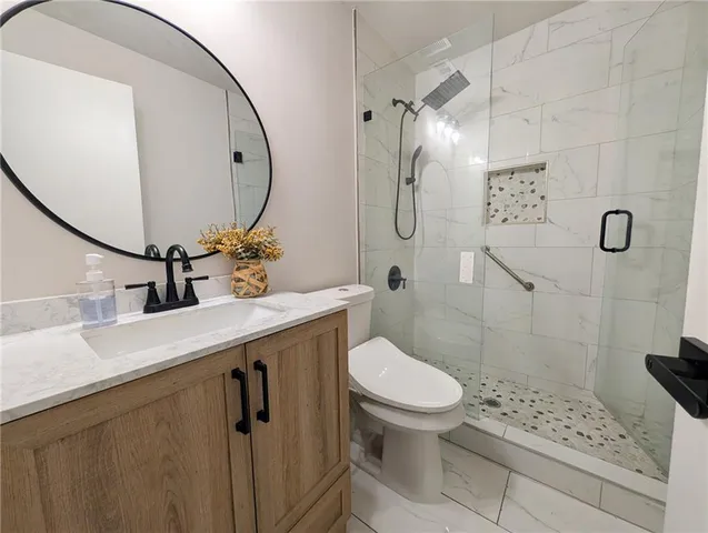 a bathroom with a sink a toilet and shower