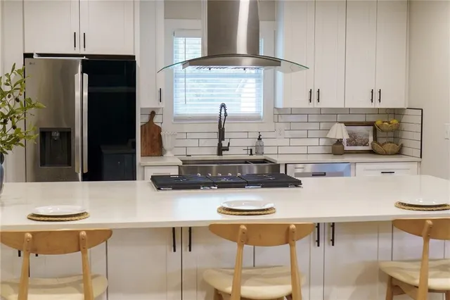 a kitchen with stainless steel appliances a dining table chairs and stove