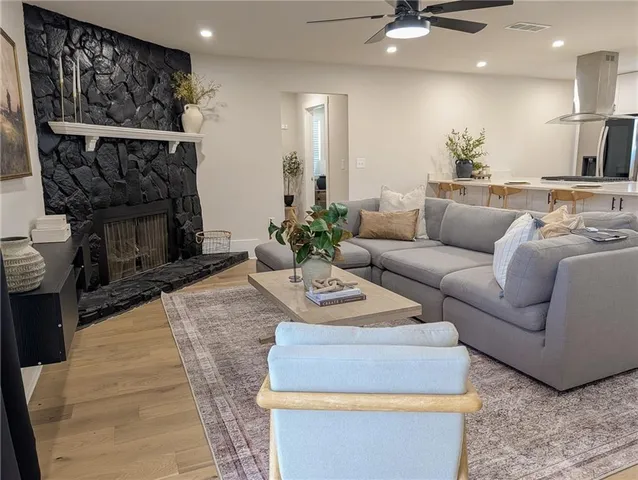 a living room with furniture a fireplace and a chandelier