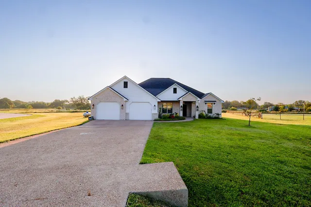 a front view of house with yard and garage