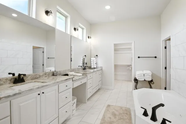 a spacious bathroom with a granite countertop sink and a mirror