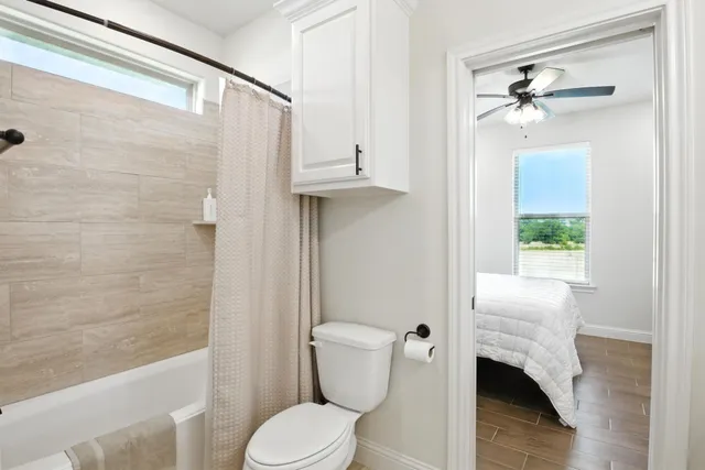 a bathroom with a toilet and a shower