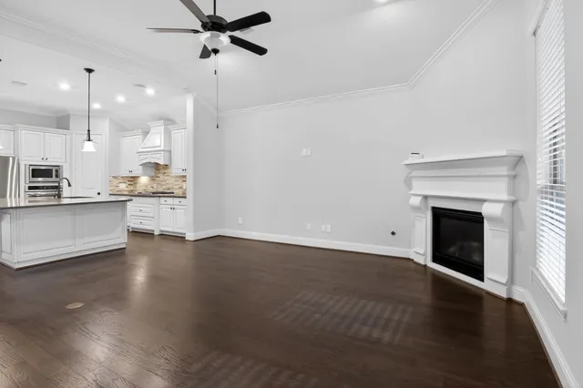 a view of a kitchen with a sink a fireplace and wooden floor