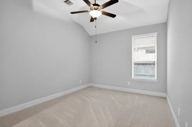 an empty room with a window and a fan