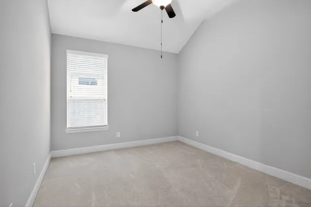 an empty room with a window and a fan
