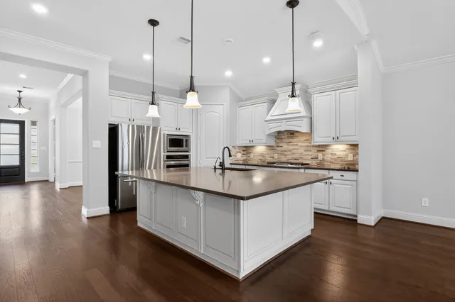 a kitchen with stainless steel appliances granite countertop wooden floors and sink