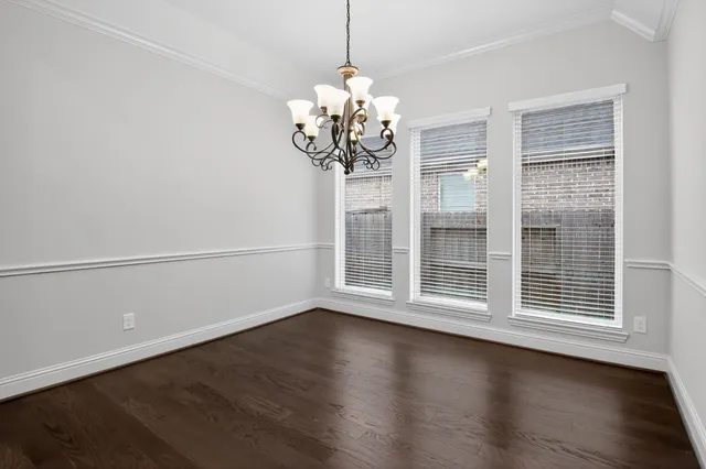 a view of a room with wooden floor and chandelier