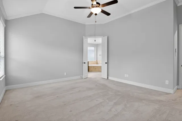 an empty room with a ceiling fan and a window