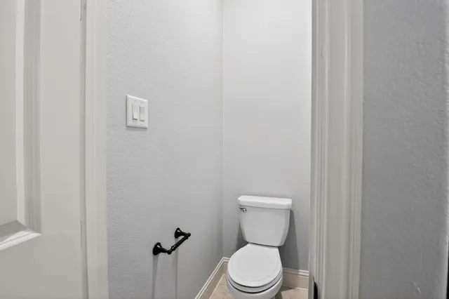 a white toilet sitting next to a white wall