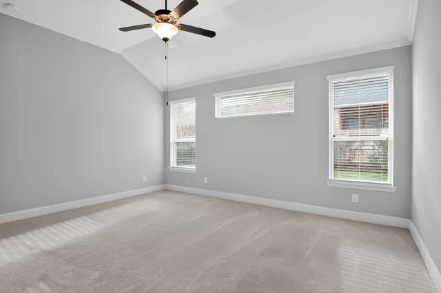 an empty room with windows and fan