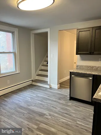 an empty room with wooden floor and cabinet
