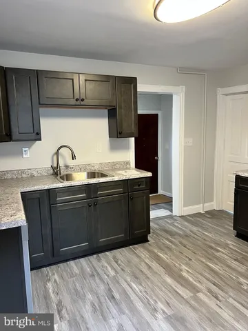 a kitchen with granite countertop a sink and cabinets