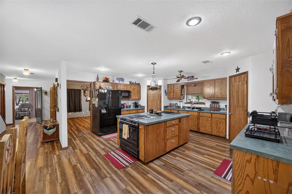10964 River Ranch Road Kemp, TX 75143 - Photo 15 of 40 Kitchen featuring wood-finish flooring, wood cabinetry, a center island with countertop, and recessed lighting