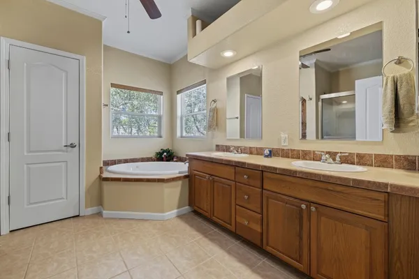 a bathroom with a granite countertop sink and mirror with bathtub