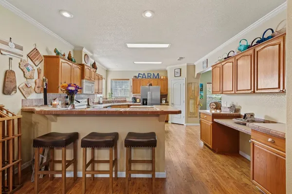 a kitchen with stainless steel appliances granite countertop a table chairs sink and cabinets
