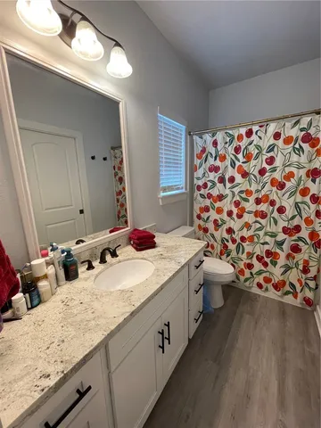 a bathroom with a granite countertop sink and a large mirror