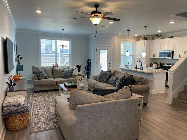 a living room with furniture ceiling fan and a window