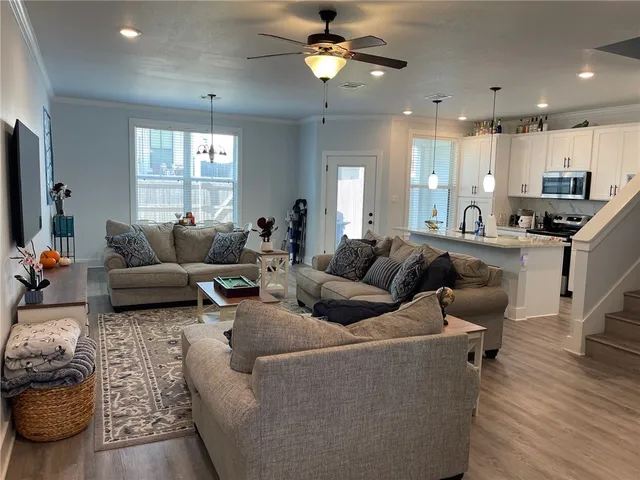 a living room with furniture a ceiling fan and a window