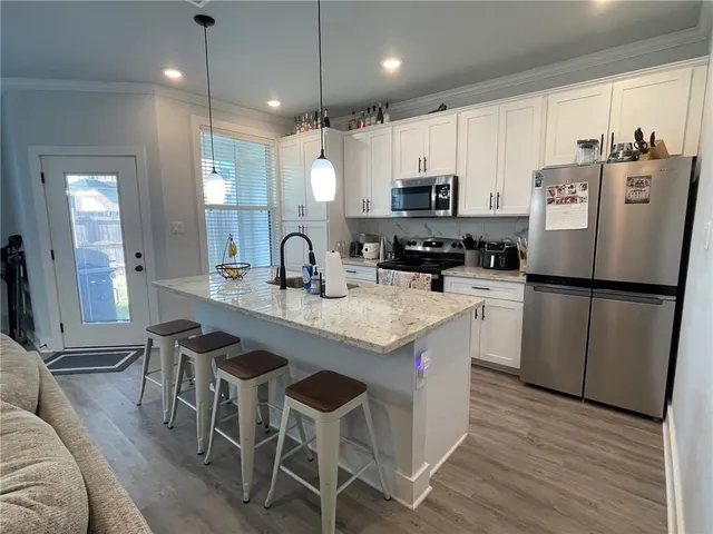 a kitchen with granite countertop a sink a center island and stainless steel appliances