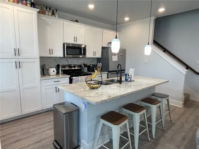 a kitchen with granite countertop a sink appliances and cabinets