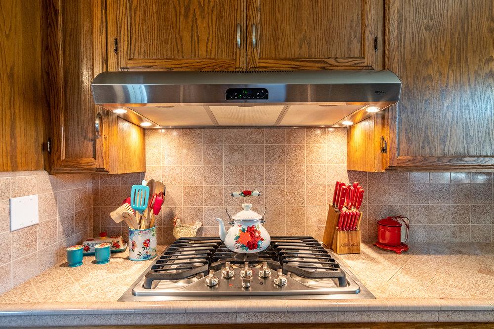 1177 Orchard Road Hollister, CA 95023 - Photo 13 of 79 a kitchen with a stove a microwave and cabinets