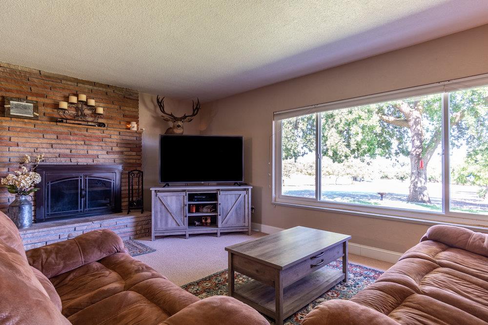 1177 Orchard Road Hollister, CA 95023 - Photo 7 of 79 a living room with furniture a flat screen tv and a fireplace